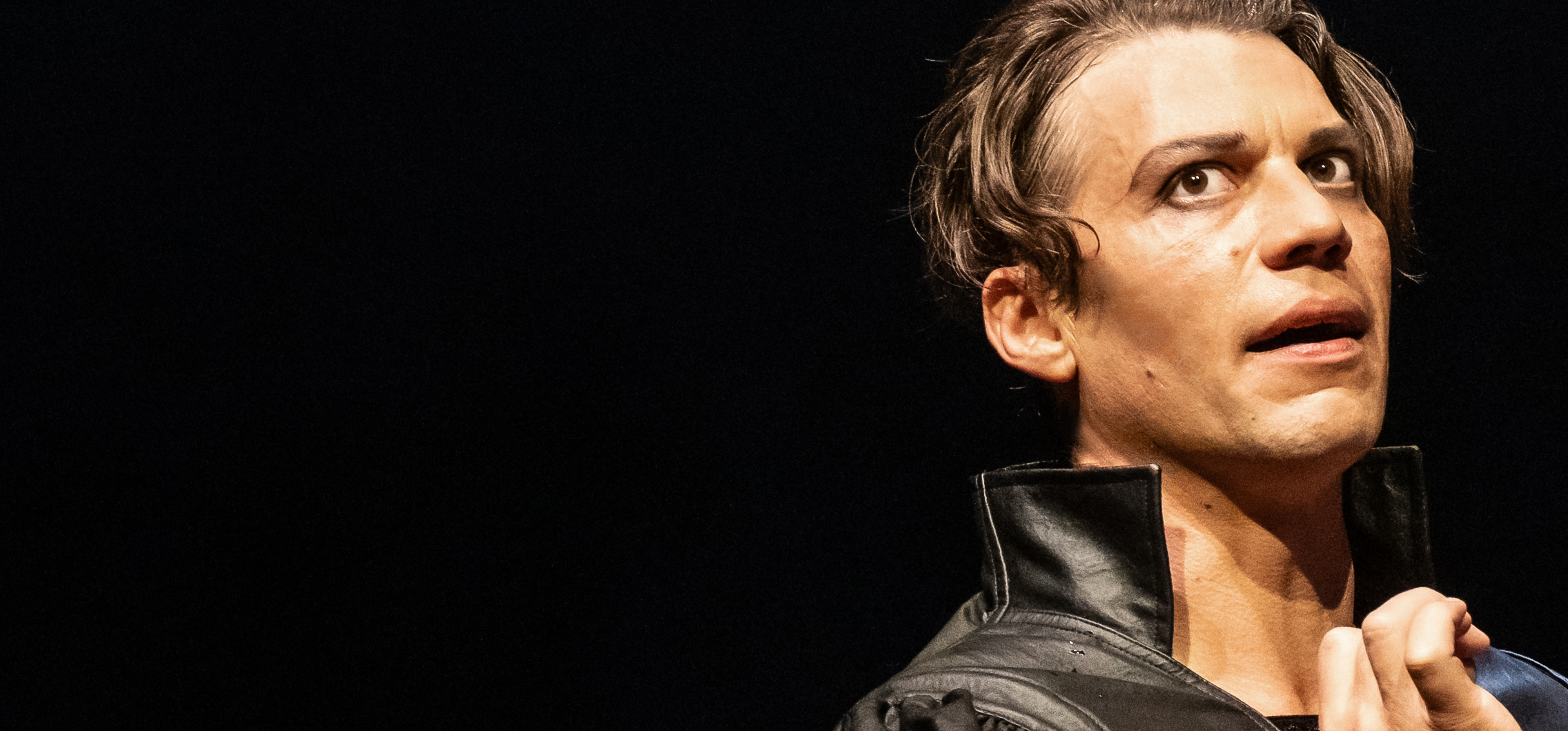 Auf rotem Untergrund stehen die Buchstaben D N T. Im Umriss der Buchstaben ist das Gesicht eines Mannes zu sehen.